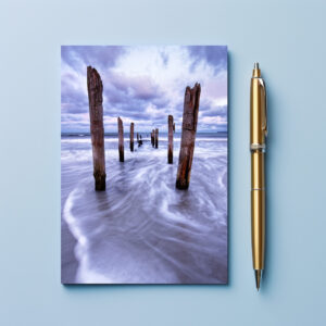 raxxa Postkarte: Holzstangen am Strand