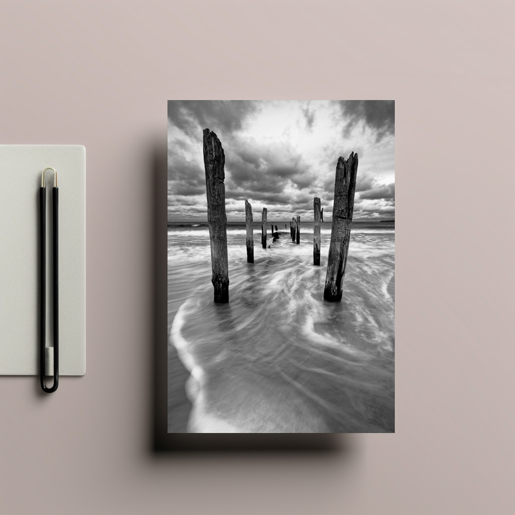 raxxa Postkarte: Holzstangen am Strand